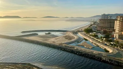 Molhes de pedra na foz dos rios Perequê e Perequezinho, com a praia ao fundo